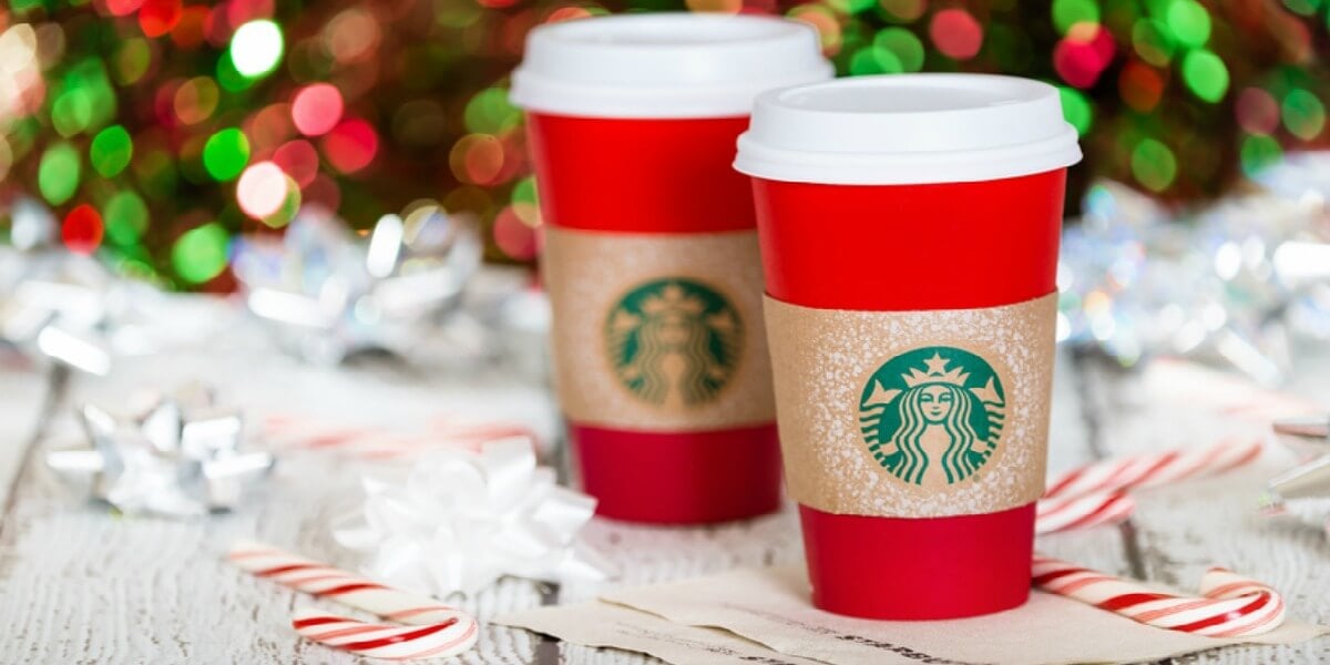 DALLAS, TX - NOVEMBER 19, 2015: A cup of Starbucks popular holiday beverage, served in the new 2015 designed red holiday cup. Displayed with candy canes against sparkly holiday background.